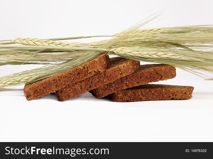 Grain cereals over the baked bread on light background