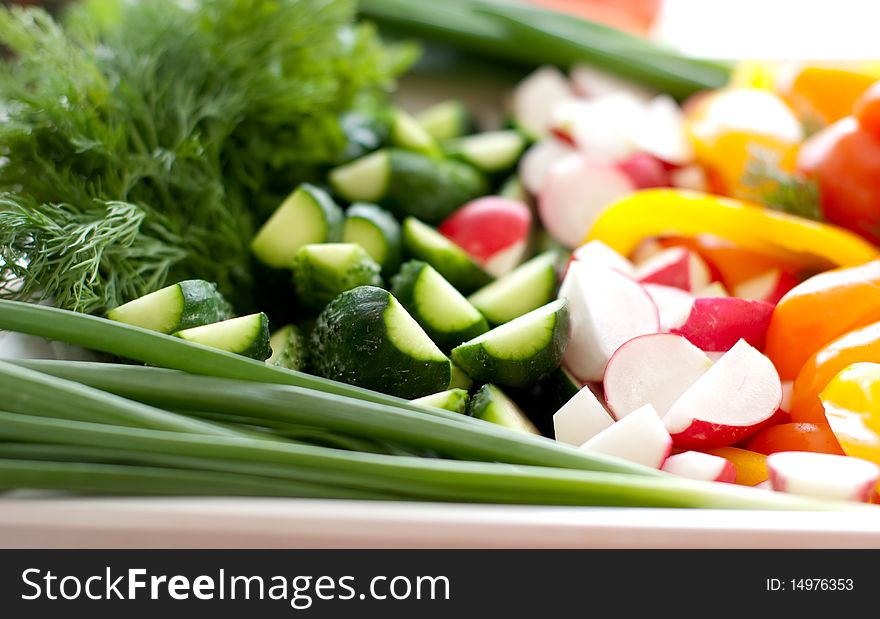 Multi-colored fresh vegetables, cut, on a plate