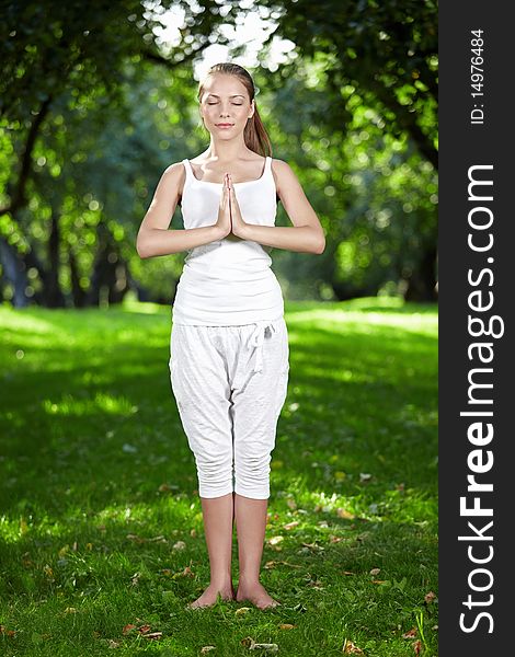 Attractive young woman practices yoga in the park. Attractive young woman practices yoga in the park