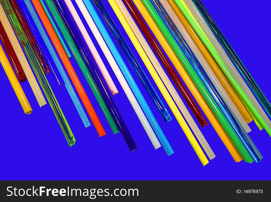 Glass sticks of different colours on a dark blue background