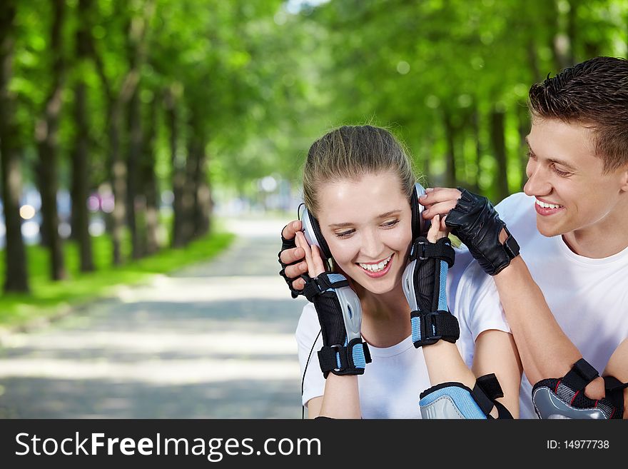 Young attractive couple with headphones in the park. Young attractive couple with headphones in the park