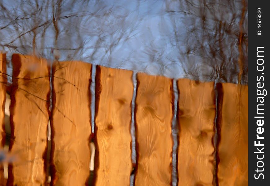 Reflexion. A Wooden Fence.