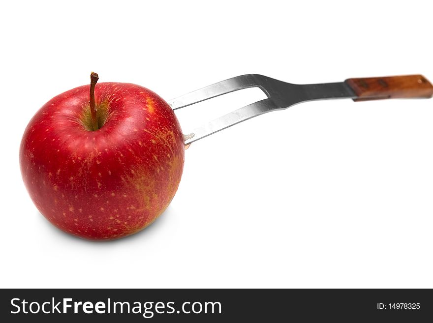 Red apple on the fork on white background