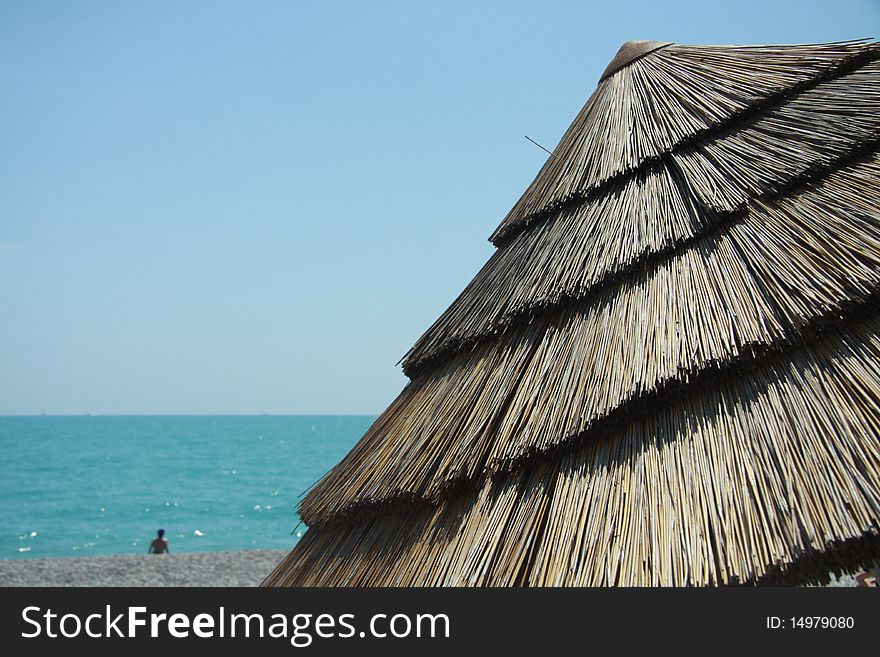 Beach straw umbrella on the beach of French Riviera