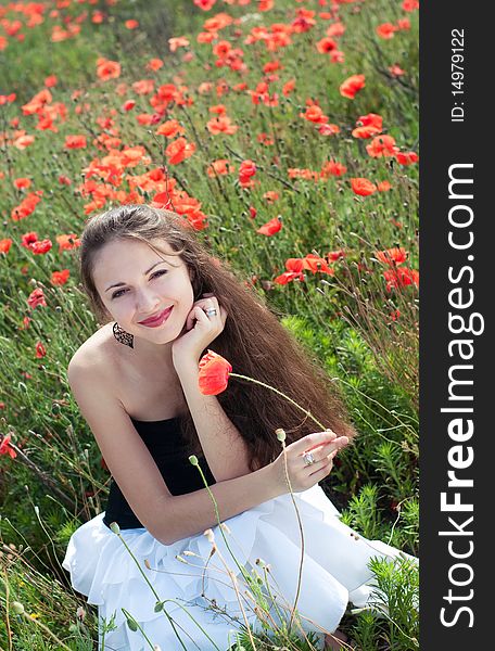 Beautiful young woman posing in the field of poppies. Beautiful young woman posing in the field of poppies