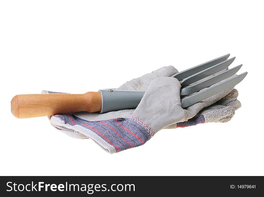 Rake for removal of weeds and a glove for work in a garden.