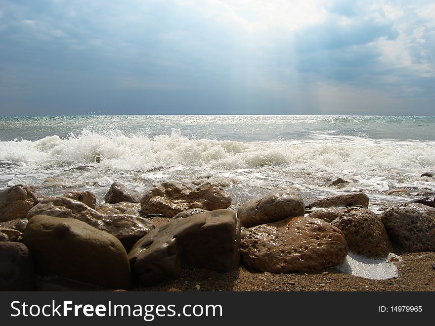 View of a stormy sea with a big stones on the coastline. View of a stormy sea with a big stones on the coastline