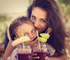 Free Happy Kid Girl And Funny Emotional Mother Drinking Berries Smoothie Juice Together In Street Summer Outdoor Cafe. Closeup Royalty Free Stock Photo - 149706685
