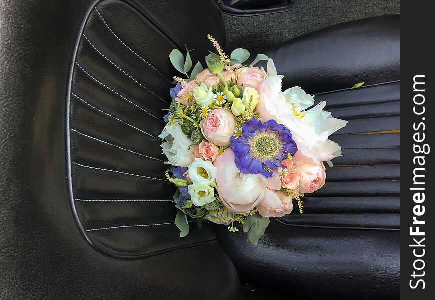 Bouquet of bridal flowers on the car seat.