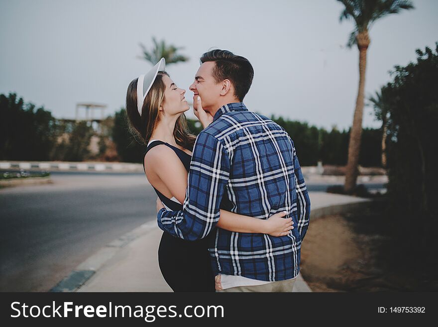 Joyful couple in love having fun, hugging, walking on road in tropical country. Beautiful sportswoman, enjoying,lovely moments, expressing positivity