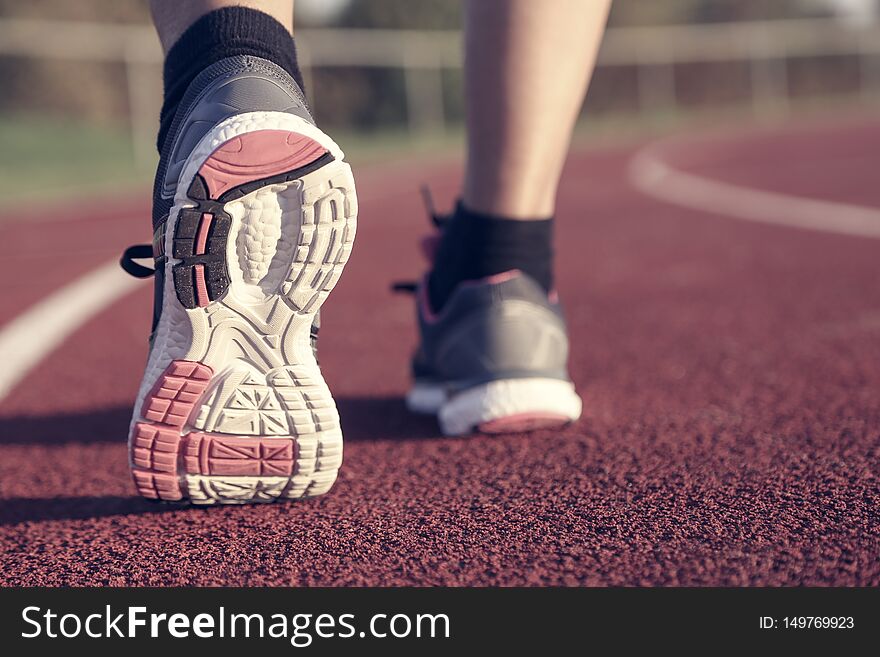 Woman running on athletic track at afternoon