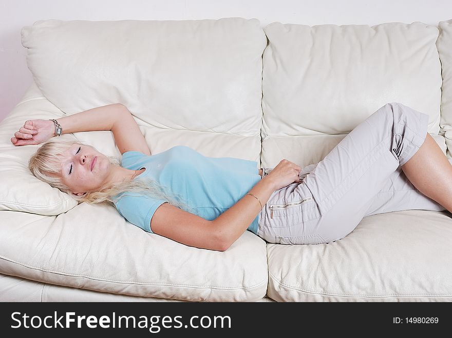 Blond woman resting  on a sofa