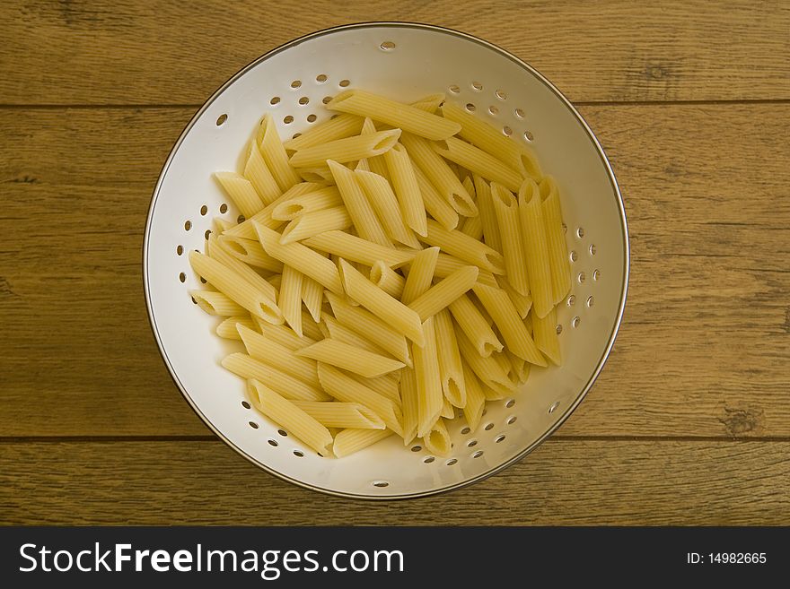 Pasta in colander on table