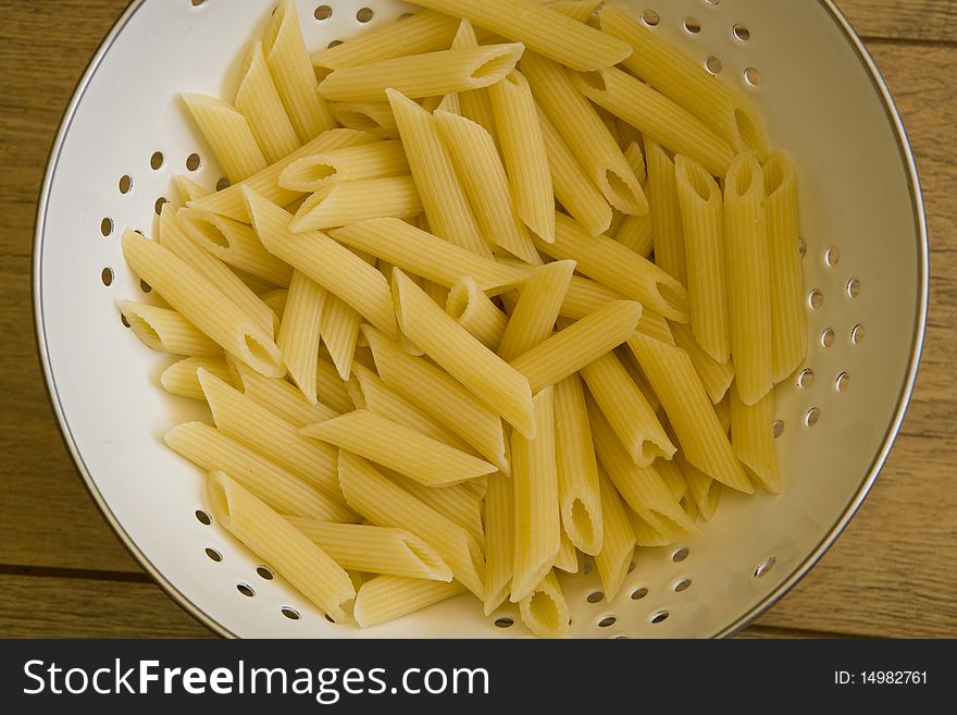 Pasta in colander on table