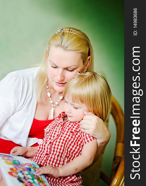 Mother and daughter sit and read the books and tell fairy tales. Mother and daughter sit and read the books and tell fairy tales