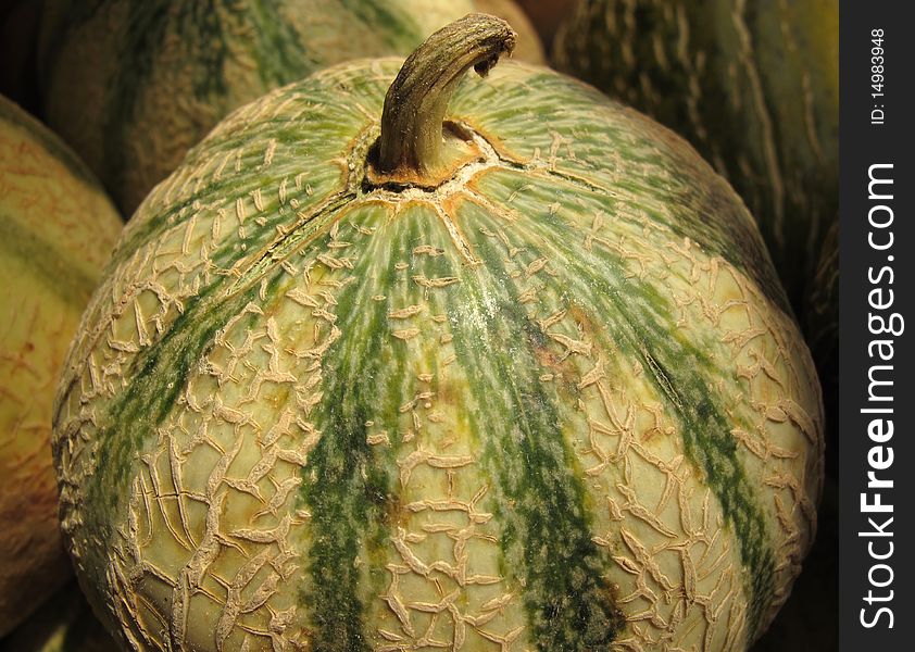 A green sugar melon offered on a market