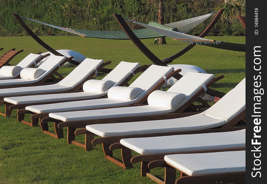 Lounge beds and hammocks at the beach of resort hotel