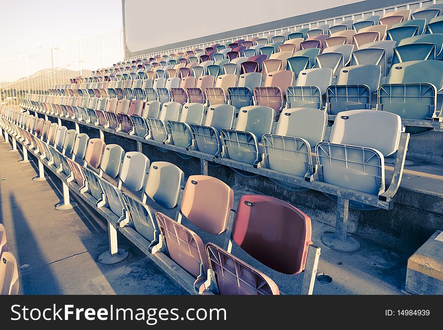 Old faded Stadium Seats on a row. Old faded Stadium Seats on a row