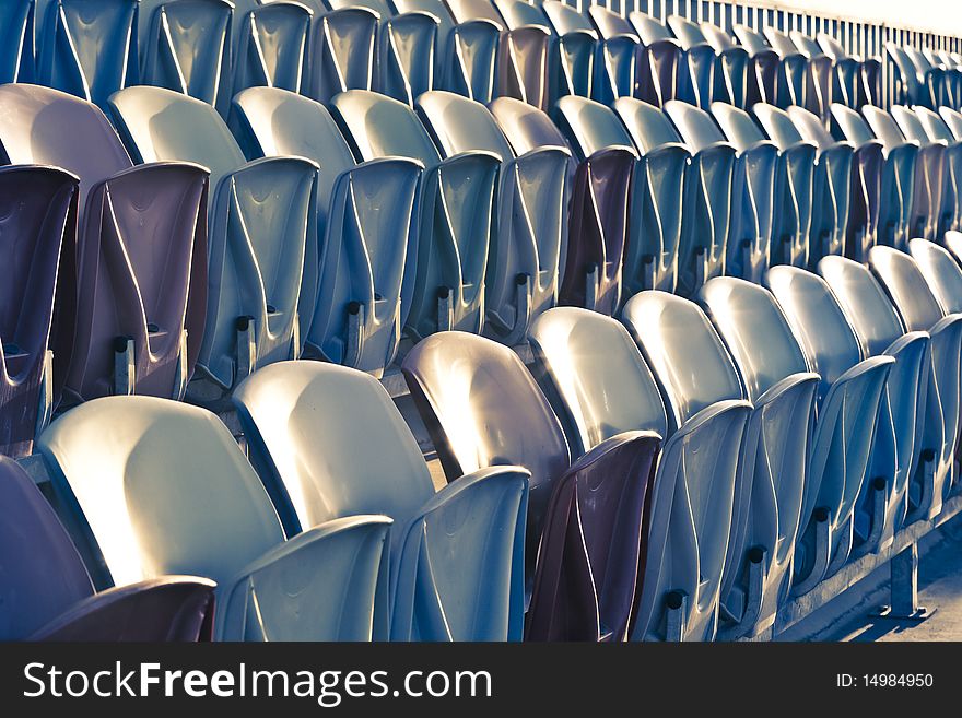 Rows of old faded Stadium Seats. Rows of old faded Stadium Seats