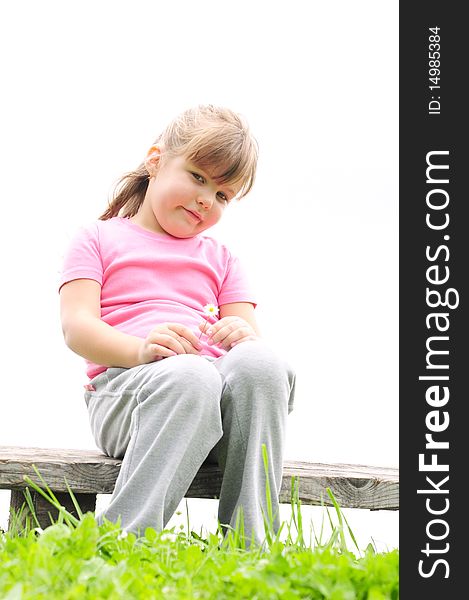 Girl sitting on a wooden bench in the grass. Girl sitting on a wooden bench in the grass