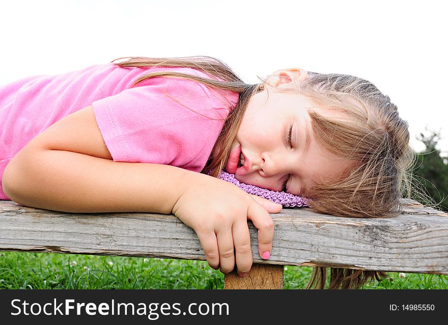 Girl sleeping on a bench in the nature of