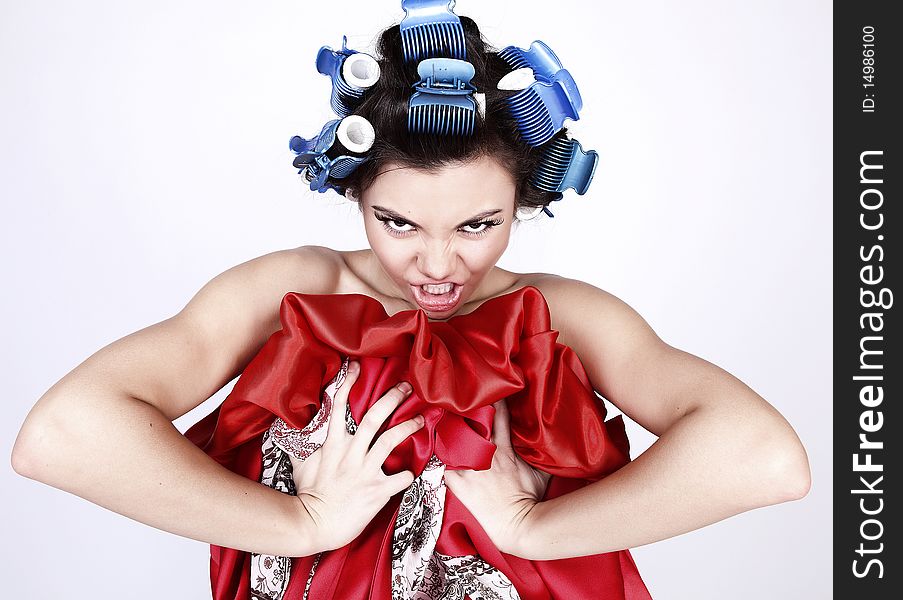 Emotional Girl with hair-curlers on her head. Photo.