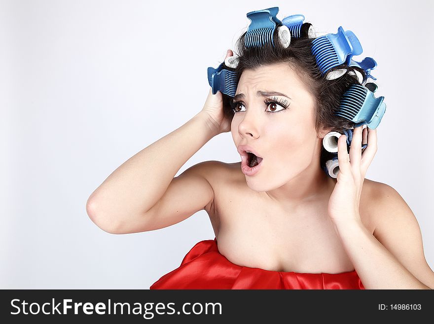 Emotional Girl with hair-curlers on her head. Photo with copyspace.