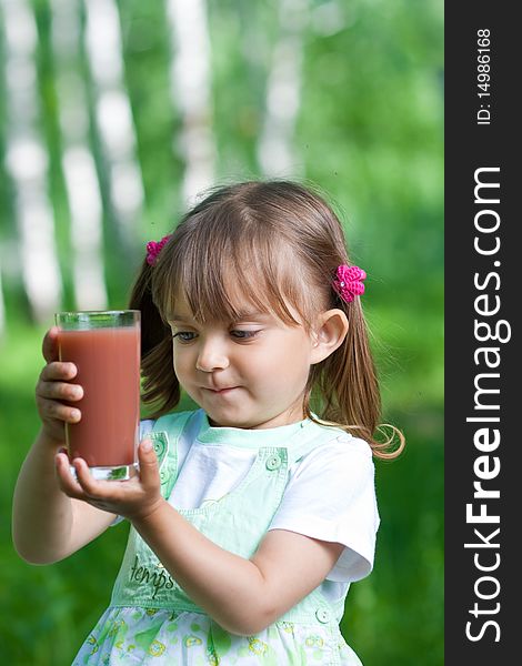Little girl portrait with glass plum or cherry juice outdoor. Little girl portrait with glass plum or cherry juice outdoor