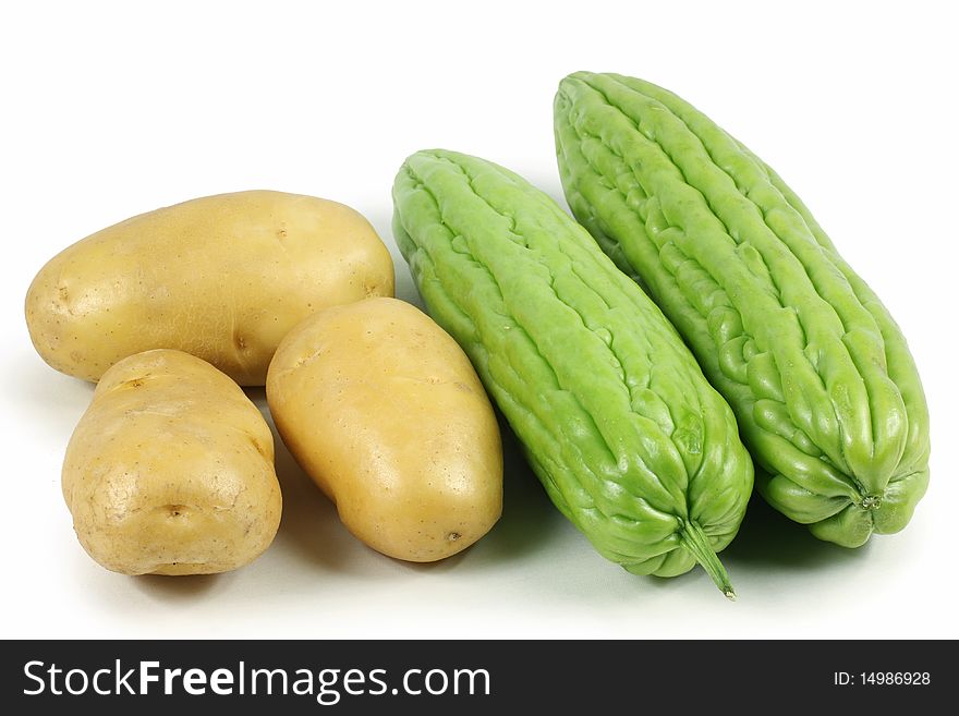 Potatoes and bitter gourd on white