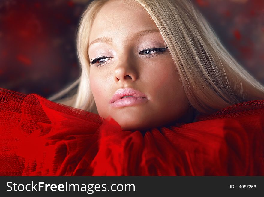 Attractive blond beauty in red theatrical jabot