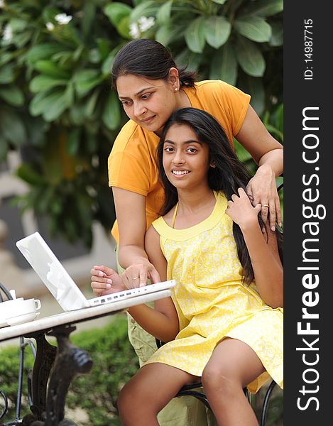 Loving Mother And Daughter With Laptop Outdoors