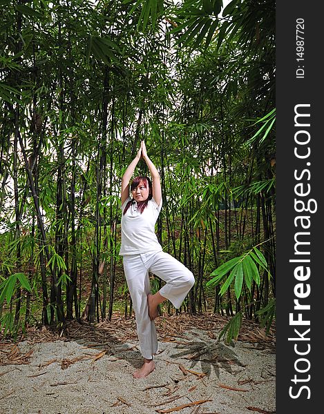 Asian Woman Practising Yoga In Woods