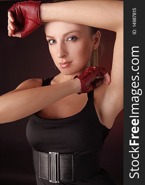 Attractive posing blonde in a red sport gloves. Fashion photo.