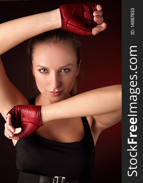 Attractive posing blonde in a red sport gloves. Fashion photo.