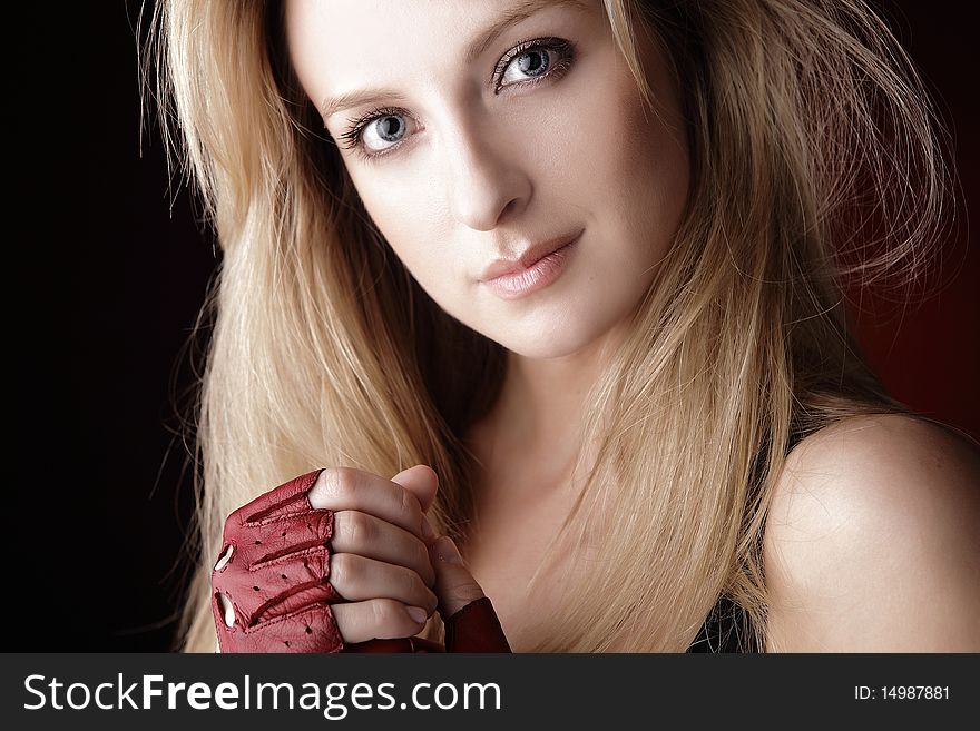 Attractive posing blonde in a red sport gloves. Fashion photo.