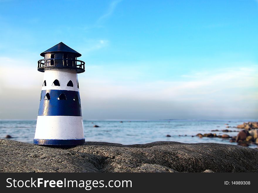 Blue and white lighthouse on a rock