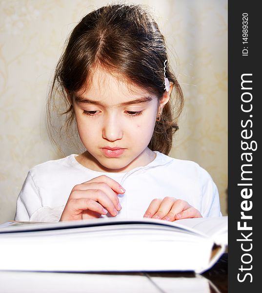 Young schoolgirl is reading book. Young schoolgirl is reading book