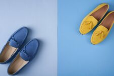 Blue Suede Man`s And Yellow Woman`s Moccasins Shoes Over Blue Background Stock Images
