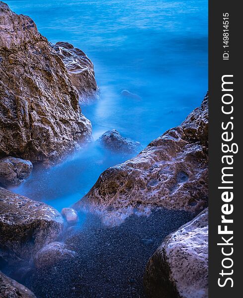 Long exposure image of Dramatic sky seascape with rock in sunset scenery background