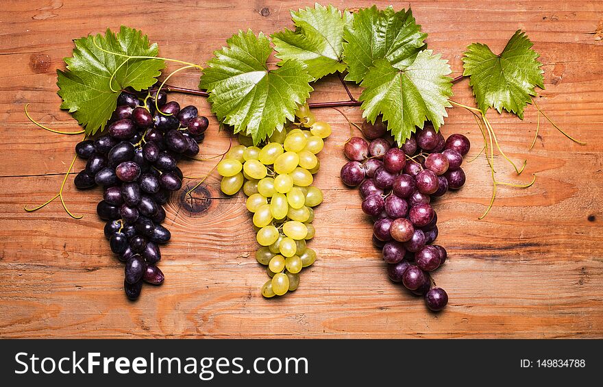 Closeup of set screw with different types of grapes on wooden board. Closeup of set screw with different types of grapes on wooden board