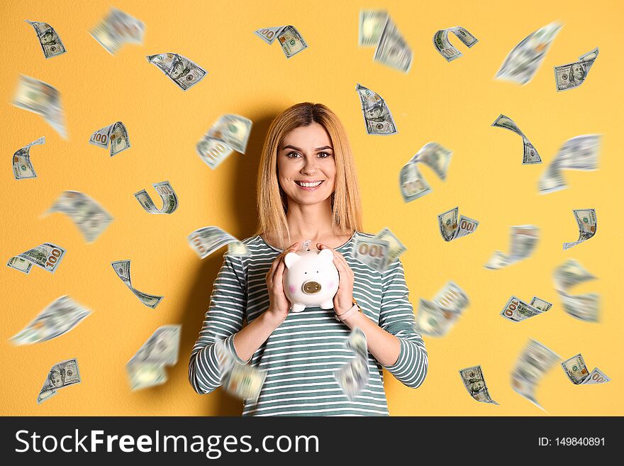Happy woman with piggy bank and flying money