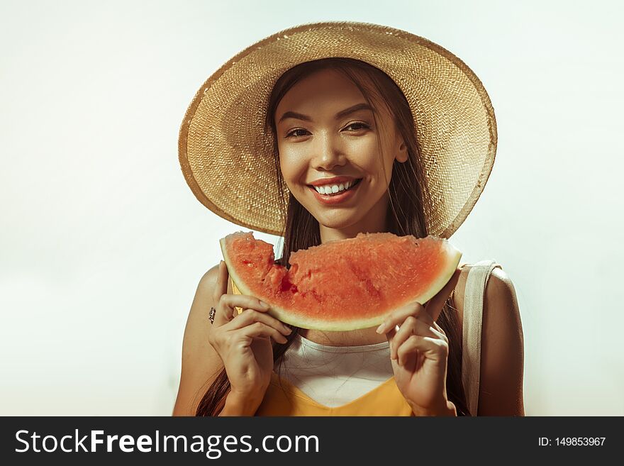 Close-up face portrait of woman keeping watermelon piece in hands.