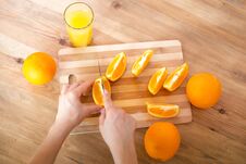 Cooking, Food And Concept Of Veganism, Vigor And Healthy Eating - Close Up Of Female Hand Cutting Orange On Slices Royalty Free Stock Photography