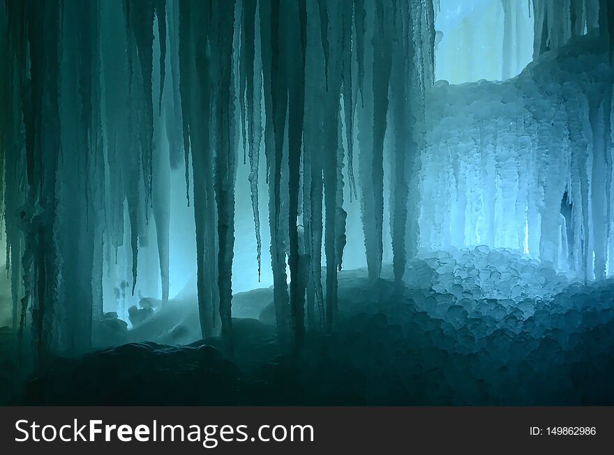 Huge ice icicles. Fragment of large blocks of ice frozen waterfall of water. Blue ice cavern background. Frozen stream waterfall. Huge ice icicles. Fragment of large blocks of ice frozen waterfall of water. Blue ice cavern background. Frozen stream waterfall