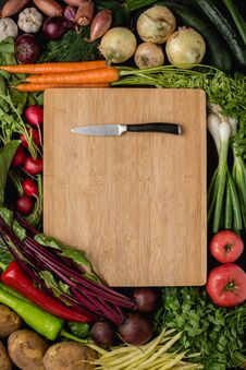 Small Kitchen Knife On Wood Cutting Board With Fresh Vegetables Stock Photos