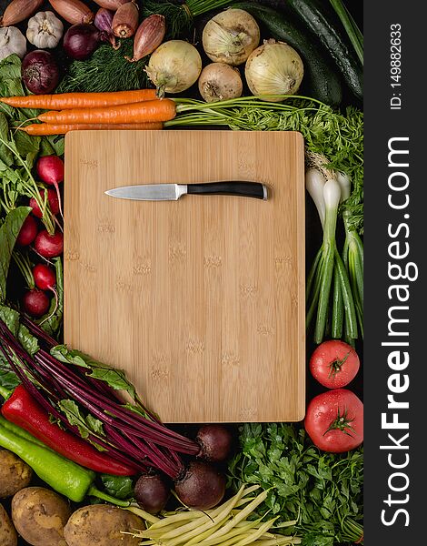 Small Kitchen Knife on Wood Cutting Board with Fresh Vegetables