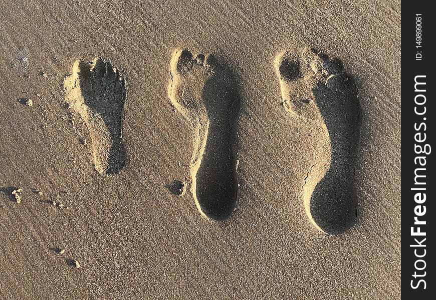 Family’s foot prints in the sand