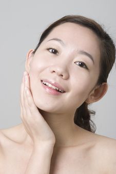 Smiling Asian Girl Touching Her Chin Royalty Free Stock Image