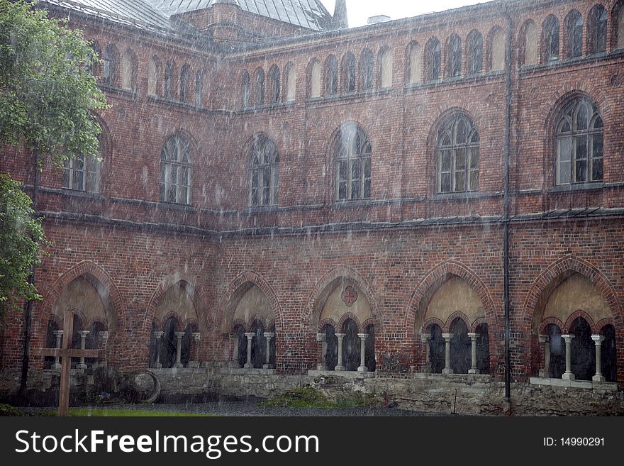 Wall of medieval cathedral with archs in rain