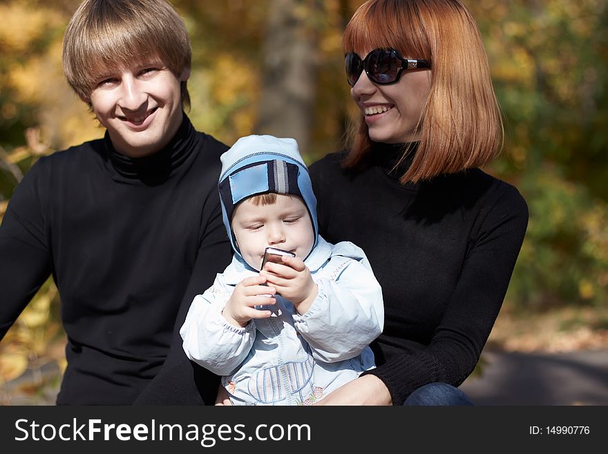 Happy family on walk in park in the autumn